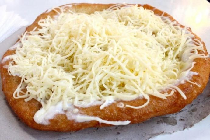 Lángos (fried dough) with cheese and sour cream, a Hungarian speciality