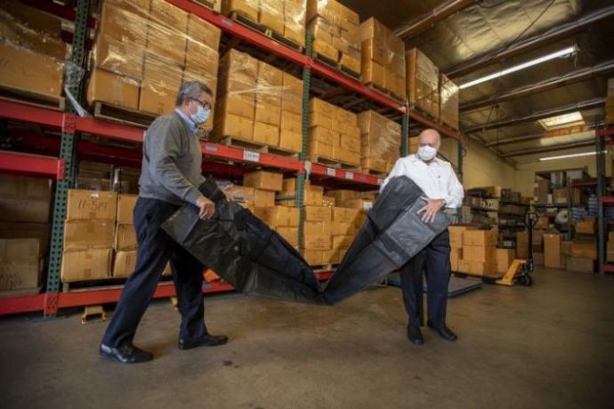 Workers unpack a body bag