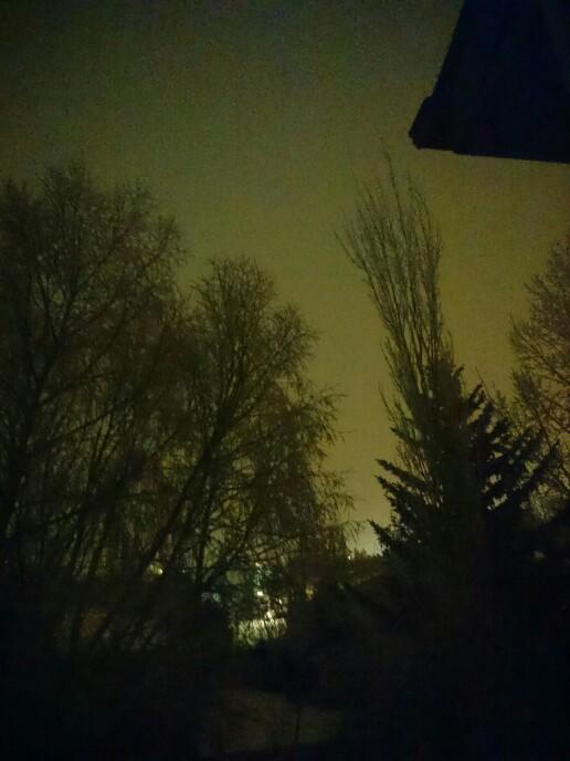 Why is the night sky a bright glowing sky normally it's a dark blue and black sky but tonight the sky is bright glowing orange red and white??