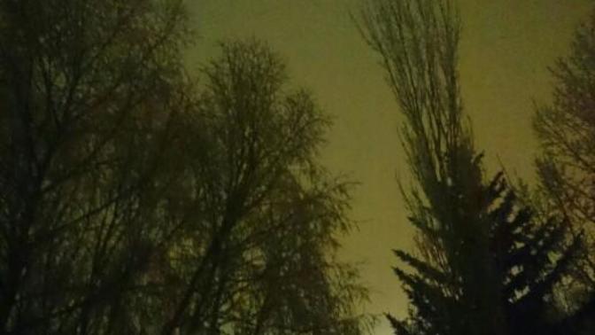 Why is the night sky a bright glowing sky normally it's a dark blue and black sky but tonight the sky is bright glowing orange red and white?