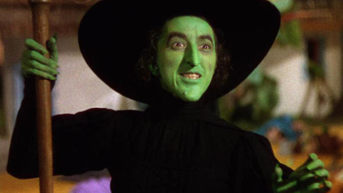 Why do witches in the pop-culture often have a pointy hat, black clothes etc?