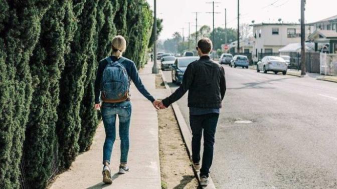 If you are a guy walking along a sidewalk with your girlfriend/wife, is it considered courteous to walk on the curb side?