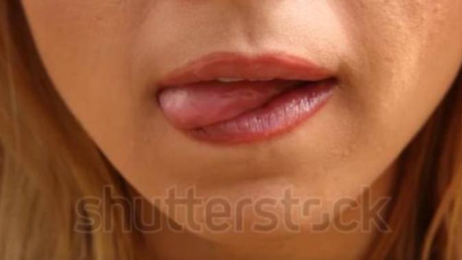 If a woman licks her lips starting at the bottom of her lip while looking at you or at your mouth like in this picture below what does it mean?