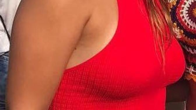 Is she wearing a bra under her red shirt?