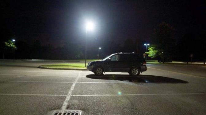 A hooded man is knocking on your car window asking for your help, what do you do?