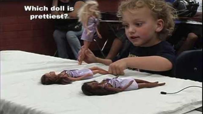 How are kids conditioned to think the white barbie is the prettiest and the black barbie doll bad?