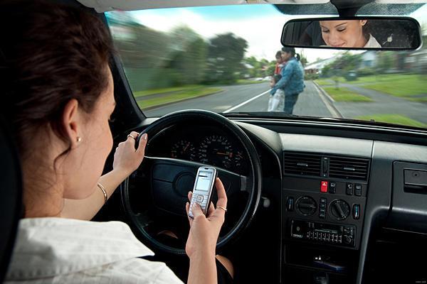 a typical driver texting while driving and not looking at the road.