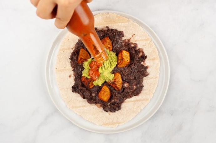 How do you apply your hot sauce on your burrito when eating? on each bite, in a dip or do you put it all on before you eat it?