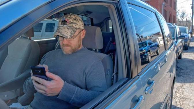 Would you find it suspicious if you saw someone waiting in their car while its still on in your neighborhood during daytime?