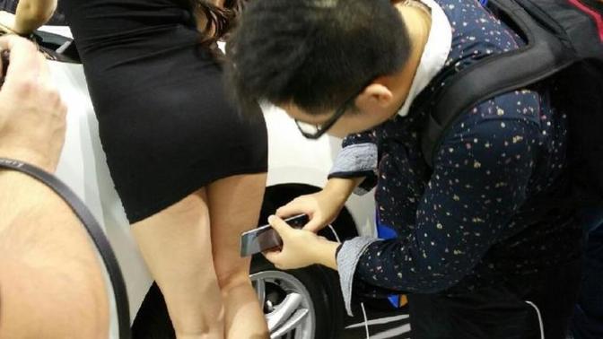 What do you think the guy with the red shoes is taking pictures of?