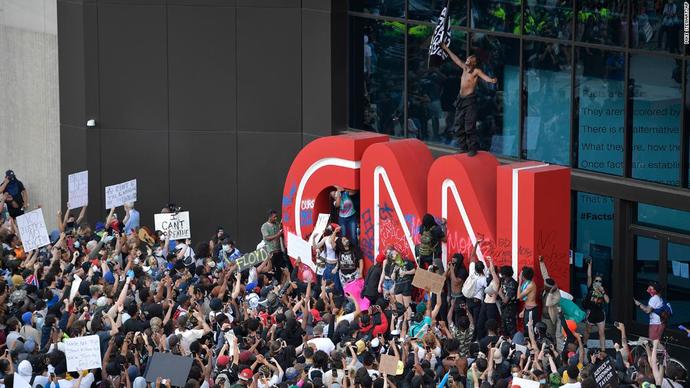 The HQ of the propaganda outlet CNN. Is the shirtless protester holding an ISIS flag?