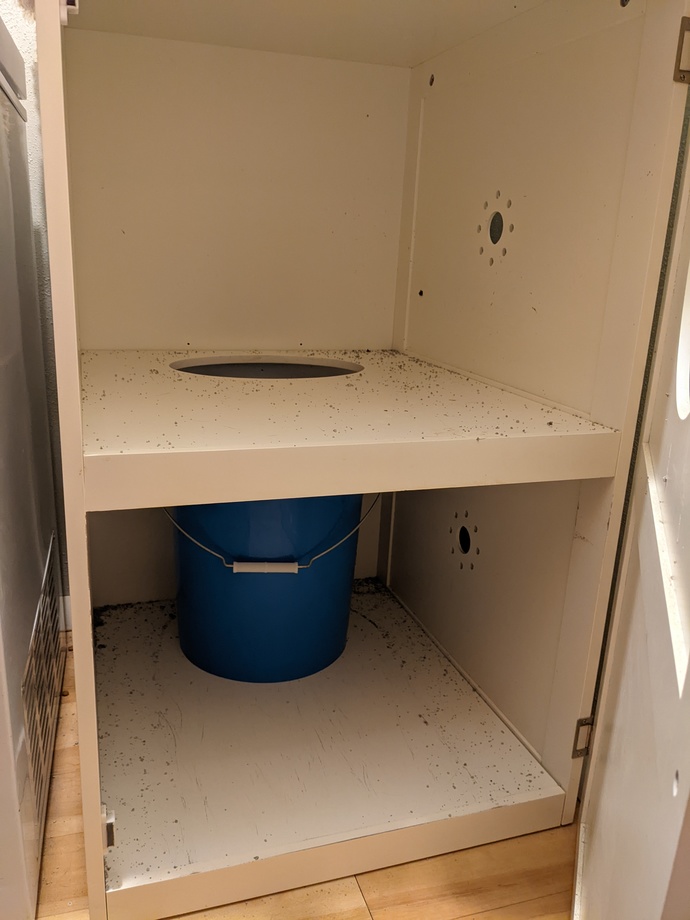 Inside with 5-gallon bucket under hole