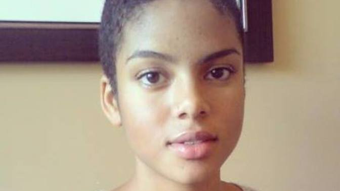 Does anyone know her name and how to describe her facial features (like fill lips, curly hair, etc)?