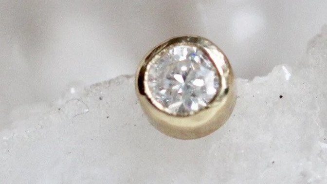 Which of these diamonds studs looks daintier for a second hole with a regular stud earring?