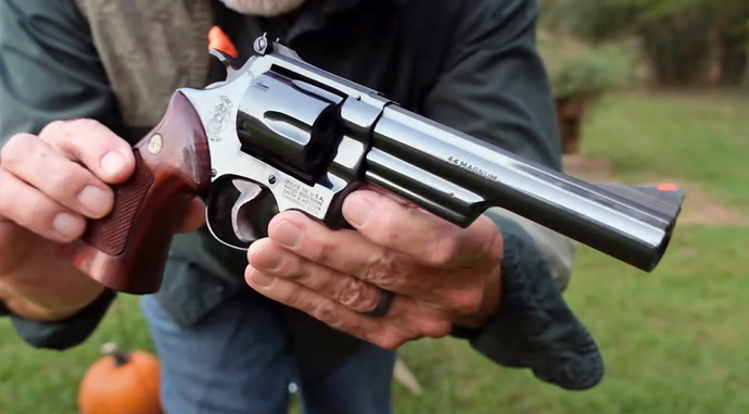 Hands you a gorgeous.44 Magnum S&W revolver
