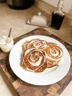 Cinnamon swirl pancakes with a cream cheese icing! Topped with pecans 