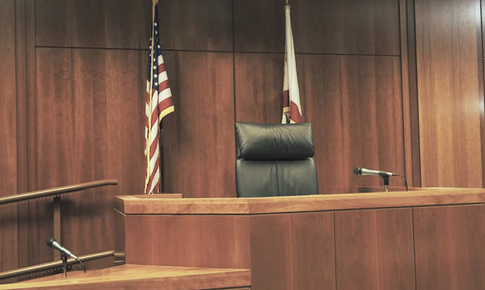 The defendant is sitting the chair. You just cant see him.