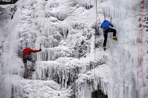 People climb an artificial frozen waterfall at a ski resort in Metabief on January 7, 2017.