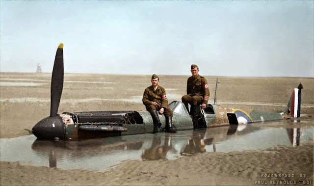 Two German members of the Organisation Todt sitting on a downed Spitfire.