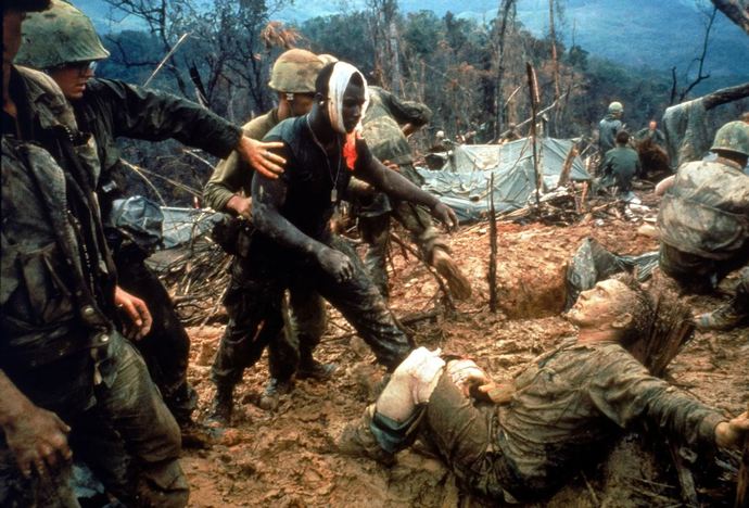 wounded US marine Jeremiah Purdie (centre) is led past stricken comrades after a fierce firefight for control of Hill 484.