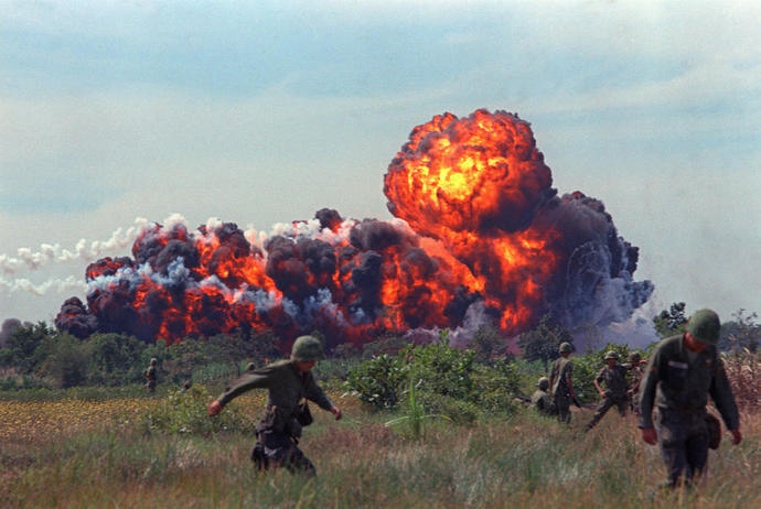 A napalm strike erupts in a fireball near U. S. troops on patrol in South Vietnam, 1966