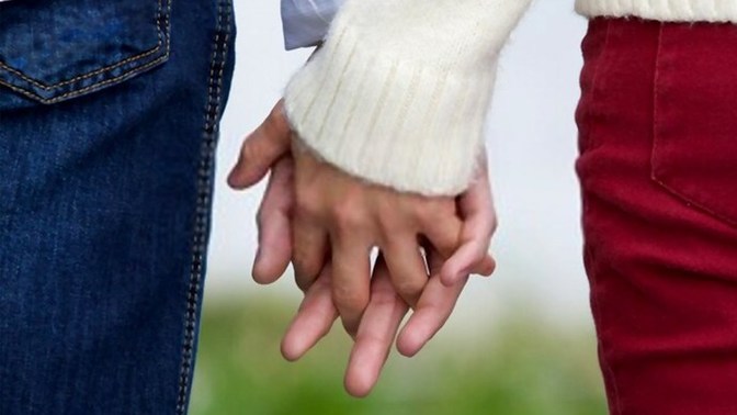 My guy friend hold my hand in front of everyone when we were sitting next to eachother and interlock fingers what does it mean?