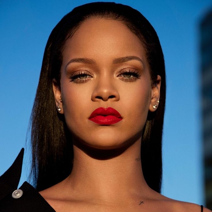 rihanna wearing bold red lips in the shade "uncensored" from her makeup brand fenty beauty