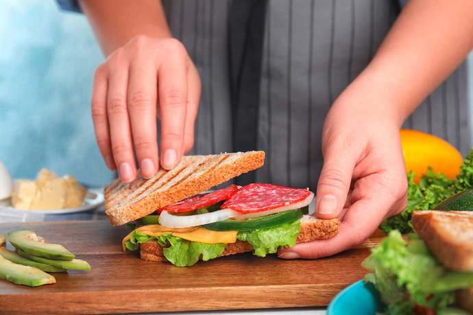 Who should go make a sandwich if asked while one stays sitting on the couch watching TV, the wife or husband and why?