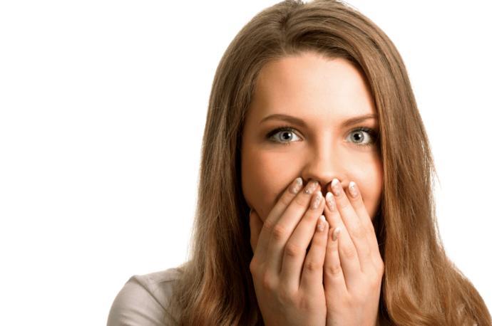 Why do women put their hand in front of their mouth?