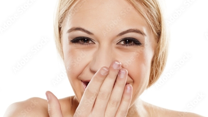Why do women put their hand in front of their mouth?