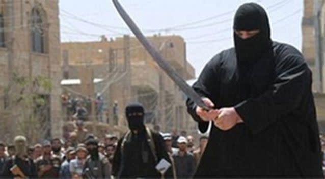 Member of Isis using a big sword to decapitate a human head