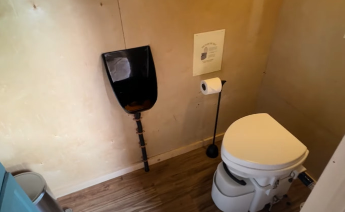 A toilet somewhere which includes both Urinal (black) and the Pot (white)