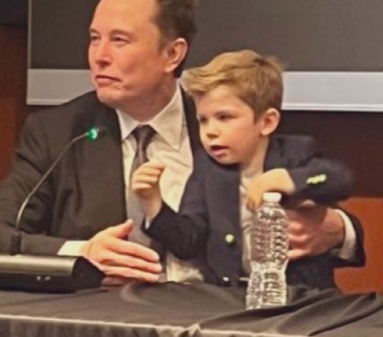 F*ckface Musk and his son, shielding his fathers upper torso