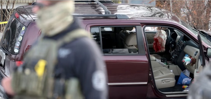 A deployed airbag and blood stains are seen in a crashed vehicle on at the scene of a shooting in Minneapolis