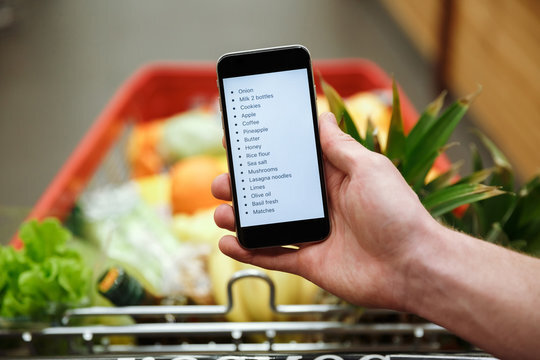 Who uses a paper list and who uses their phone to grocery shop?