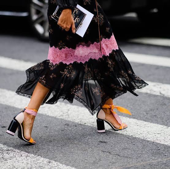 Why do some women wear high heels even when they struggle to walk in them?
