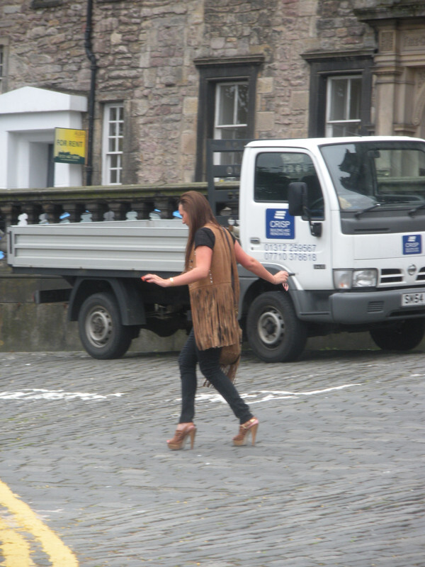 Why do some women wear high heels even when they struggle to walk in them?