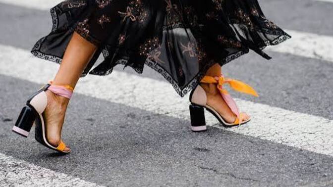 Why do some women wear high heels even when they struggle to walk in them?