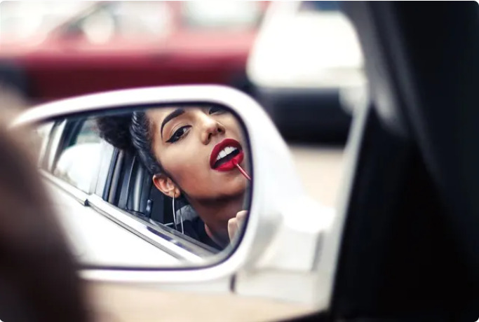 Why are women more than twice as likely to engage in risky behavior distracted driving by fixing their appearance while driving than men?