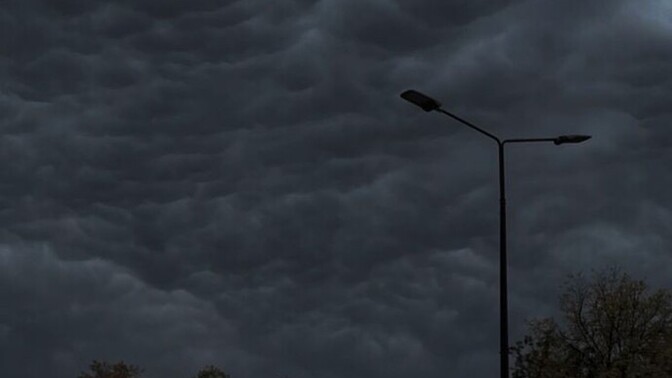 What causes nimbostratus clouds to form and produce steady rain?